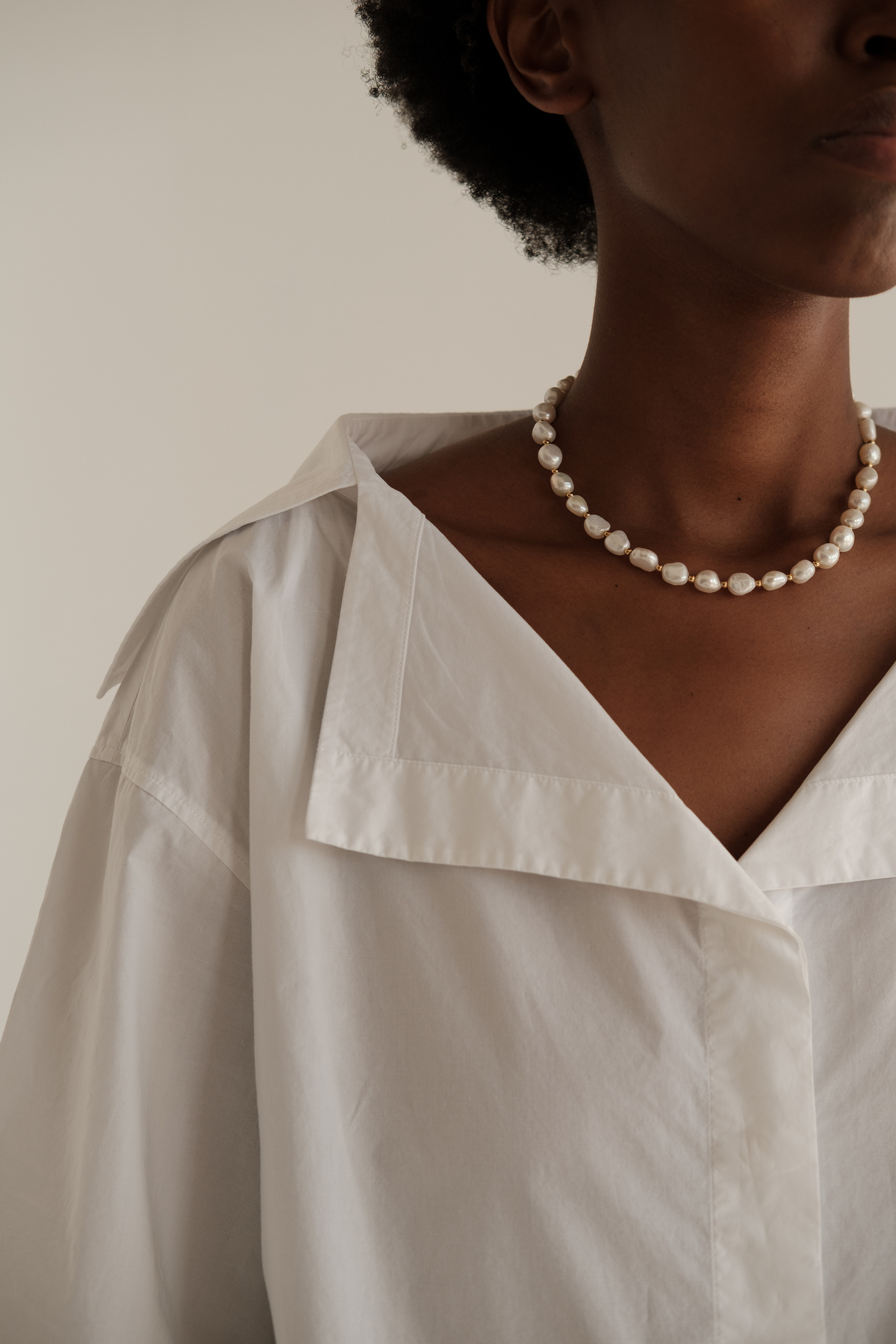 Woman in Casual Dress Shirt and Pearl Necklace